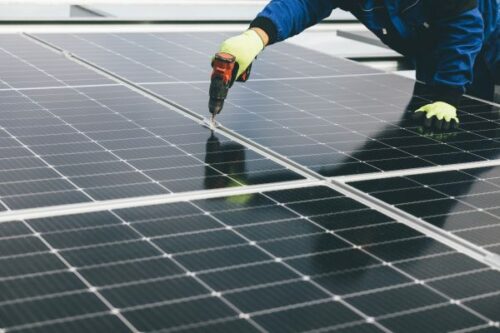 man repairing solar panel
