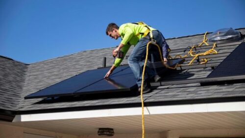 man fitting solar panel